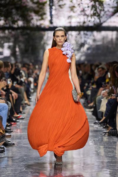 这组造型展示的是 Christian Dior 2026 春夏高级定制系列。花卉刺绣、蓬体礼服、柔性褶裥与艺术装置共同营造出“当代花园剧场”。橙色气球廓形、白色云朵裙、黑色花卉礼服与手工植物装饰形成强烈层次，系列将自然意象重新转化为高级时装语言。整体既保留 Dior 高定传统中的浪漫主义，又融入实验雕塑感，使秀场更像一次关于花园、记忆与收藏的艺术展演。——来自顽石频道国际流行趋势分析。